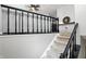 Carpeted staircase with dark railings and a ceiling fan above, leading to the upper level at 1103 Rosengarten Dr, Greenwood, IN 46142
