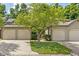 Lovely exterior of a multi-unit home featuring well-manicured lawns, mature shade tree, and attached garages at 11529 Sunset Cove Ln # 11529, Indianapolis, IN 46236