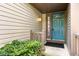 Welcoming front porch featuring a vibrant turquoise front door, manicured shrubbery, and stylish exterior details at 11529 Sunset Cove Ln # 11529, Indianapolis, IN 46236