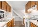Bright kitchen showcasing wood cabinets and direct access to the upper-level stairs at 11529 Sunset Cove Ln # 11529, Indianapolis, IN 46236
