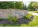 Elegant stone community sign 'Sunset Cove at Geist' surrounded by vibrant landscaping and colorful flowers at 11529 Sunset Cove Ln # 11529, Indianapolis, IN 46236