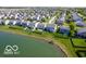 Aerial view showcases a residential neighborhood with houses bordering a pond and green spaces at 12584 Cold Stream Rd, Noblesville, IN 46060
