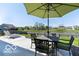 Backyard patio with outdoor seating under an umbrella, overlooking a tranquil pond at 12584 Cold Stream Rd, Noblesville, IN 46060