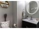 Bright half-bathroom featuring a round mirror, a modern sink and toilet, and decor at 12584 Cold Stream Rd, Noblesville, IN 46060