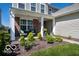 Inviting front porch with a seating area and tastefully landscaped garden bed at 12584 Cold Stream Rd, Noblesville, IN 46060