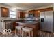 Well-lit kitchen with stainless steel appliances, dark countertops and warm wood cabinets at 12584 Cold Stream Rd, Noblesville, IN 46060