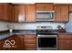 Close-up of kitchen with stainless steel appliances, dark countertops and warm wood cabinets at 12584 Cold Stream Rd, Noblesville, IN 46060