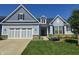 Charming blue home featuring a two-car garage, dormer window, and professionally landscaped front yard at 12634 Mustard Seed Ct, Fishers, IN 46038
