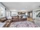 Open-concept living space with a large leather sectional, a view into the modern kitchen, and great natural light at 12634 Mustard Seed Ct, Fishers, IN 46038
