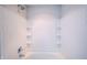 Bright, tiled bathtub and shower combination featuring a modern showerhead and convenient built-in shelving at 1336 Danielle Rd, Lebanon, IN 46052
