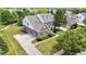 Aerial view of a beautiful brick home with a well-manicured lawn and a long driveway leading to a garage at 13624 Alston Dr, Fishers, IN 46037
