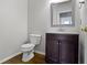 Cozy half bathroom with wood floor, elegant mirror, and dark vanity offering a touch of sophistication at 13624 Alston Dr, Fishers, IN 46037