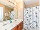 Bright bathroom featuring double sinks, vanity, and a decorative shower curtain at 13700 Stanford Dr, Carmel, IN 46074