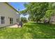 Exterior view of the home with a large, grassy backyard and concrete patio area with outdoor furniture at 14523 Lee Stewart Ln, Fishers, IN 46038