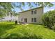 Exterior view of the home reveals a spacious backyard with patio, grill, and mature trees for shade at 14523 Lee Stewart Ln, Fishers, IN 46038