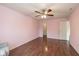 Bedroom with ceiling fan, hardwood floors, pink walls and trim, and a glimpse into a walk-in closet at 14523 Lee Stewart Ln, Fishers, IN 46038