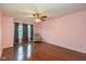 Spacious bedroom with hardwood floors, a ceiling fan, a sitting chair, and natural light from the window at 14523 Lee Stewart Ln, Fishers, IN 46038