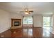 Living room featuring a cozy brick fireplace, hardwood floors, and natural light from the sliding doors at 14523 Lee Stewart Ln, Fishers, IN 46038