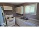 Bright kitchen featuring white appliances, cabinets, and countertops, illuminated by natural light from a window at 1521 N Tacoma Ave, Indianapolis, IN 46201