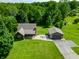 Aerial view of a charming home with a large yard, patio, and detached garage surrounded by lush trees at 155 Hoover Dr, , IN 46164