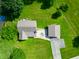 Aerial view of a home with a patio and detached garage surrounded by lush greenery and expansive lawns at 155 Hoover Dr, , IN 46164