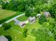Aerial view of the home nestled amongst mature trees and green lawn with detached garage and patio at 155 Hoover Dr, , IN 46164