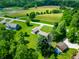 Aerial view of the home with large lawn, patio, and detached garage in a verdant, wooded setting at 155 Hoover Dr, , IN 46164