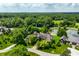 Scenic aerial view of home nestled on lush grounds with mature trees and a large pond at 18 Lost Run Ln, Zionsville, IN 46077