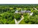 Expansive aerial view of estate home with mature trees, a pond and winding drive at 18 Lost Run Ln, Zionsville, IN 46077