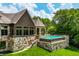 Backyard view of the pool with stone facade, outdoor seating and mature trees at 18 Lost Run Ln, Zionsville, IN 46077