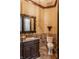 Elegant powder room featuring granite countertops, decorative mirror, and travertine tile at 18 Lost Run Ln, Zionsville, IN 46077