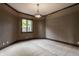 Empty bedroom with neutral carpet, trim and a large window overlooking lush backyard at 18 Lost Run Ln, Zionsville, IN 46077