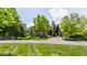 Stunning stone and wood home with lush landscaping, mature trees, and a circular driveway creates great curb appeal at 18 Lost Run Ln, Zionsville, IN 46077