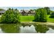 Exterior lake view shows large house with stone facade, large windows, and manicured lawn at 18 Lost Run Ln, Zionsville, IN 46077