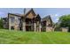 Back of beautiful home with stone and stained wood features and manicured lawn at 18 Lost Run Ln, Zionsville, IN 46077