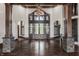 Expansive foyer with dark wood floors, stone accents, large front doors and elegant lighting at 18 Lost Run Ln, Zionsville, IN 46077