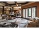 Spacious living room featuring beamed ceilings, stone floors, and access to the outdoors at 18 Lost Run Ln, Zionsville, IN 46077