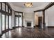 Bright living room with dark hardwood floors, fireplace, many windows, and access to back patio at 18 Lost Run Ln, Zionsville, IN 46077