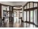 Open living room with wood floors, stone accents, wooden beams, and large windows offering natural light at 18 Lost Run Ln, Zionsville, IN 46077