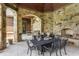Covered outdoor dining area with stone fireplace, grilling area, and beautiful stone arches overlooking the yard at 18 Lost Run Ln, Zionsville, IN 46077