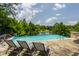 Gorgeous infinity pool with lounge chairs overlooking mature trees and lake at 18 Lost Run Ln, Zionsville, IN 46077