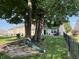Spacious backyard featuring mature trees, green lawn, a swing set, and a slide for outdoor enjoyment at 1820 Irish Lake Ln, Indianapolis, IN 46239