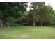Lush green backyard with mature trees, offering a serene and private outdoor space for relaxation and recreation at 1820 Irish Lake Ln, Indianapolis, IN 46239