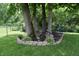 Landscaped backyard featuring mature trees, a swing, and a garden bed, enhancing the property's outdoor appeal at 1820 Irish Lake Ln, Indianapolis, IN 46239