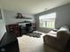 Well-lit home office featuring a comfortable couch, desk setup, and natural light from a window at 1820 Irish Lake Ln, Indianapolis, IN 46239