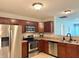 Bright kitchen features stainless steel appliances and sleek countertops with wood cabinets at 1820 Irish Lake Ln, Indianapolis, IN 46239