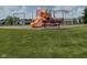 Community playground with slides, swings, and climbing bars in a lush green neighborhood at 1820 Irish Lake Ln, Indianapolis, IN 46239