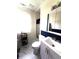 Well-lit bathroom with wainscoting, shower, new vanity, and a marble look floor at 206 Allen Ln, Greenfield, IN 46140