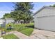 Detached white garage with a well-maintained yard, featuring a fenced-in area and colorful plants adding charm at 206 Allen Ln, Greenfield, IN 46140