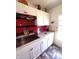 Galley kitchen with red backsplash, white cabinets, granite countertops, and stainless steel sink at 206 Allen Ln, Greenfield, IN 46140
